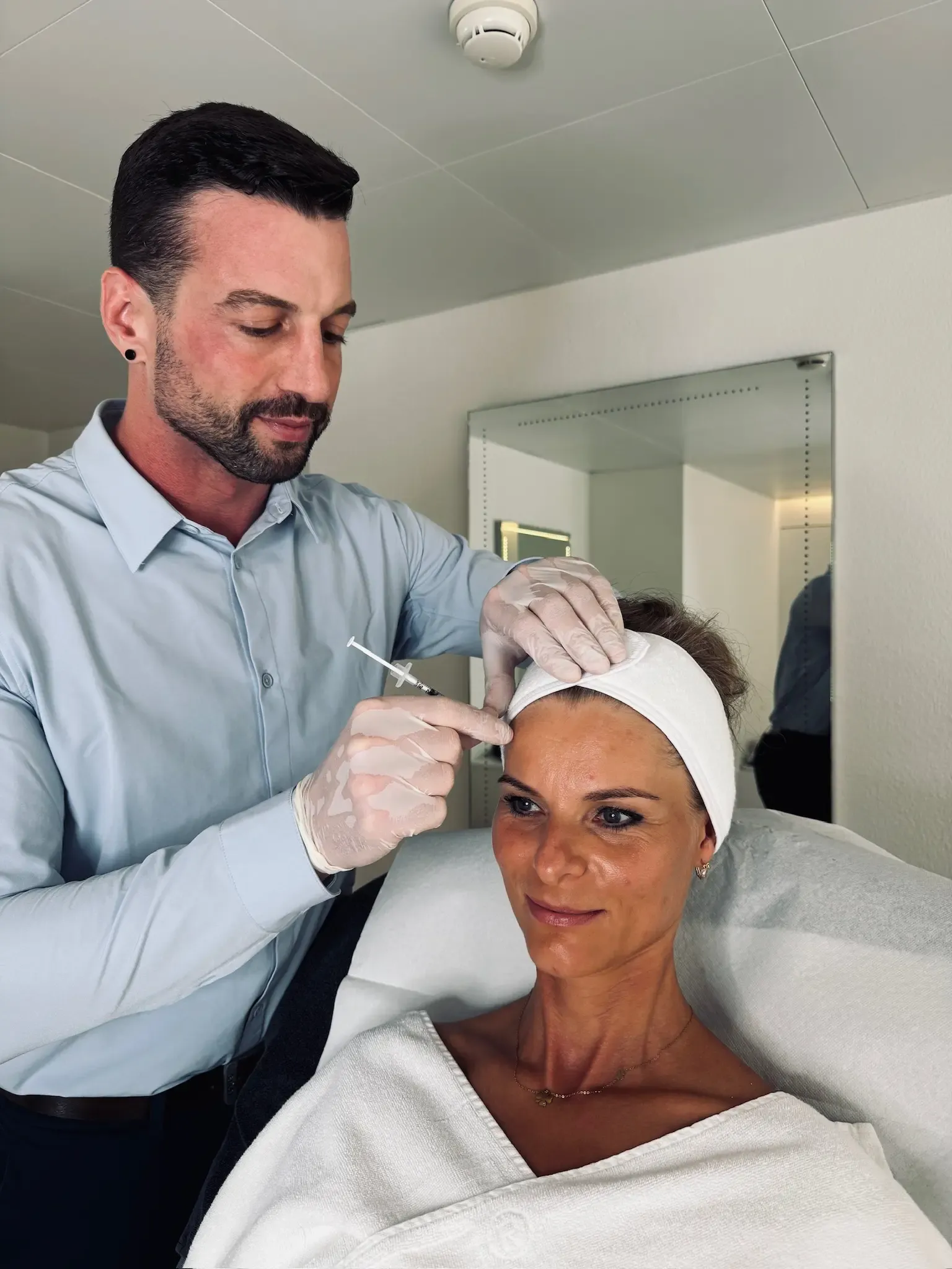 Dr. Scheffbuch injiziert einer Patientin Botulinumtoxin in die Stirn